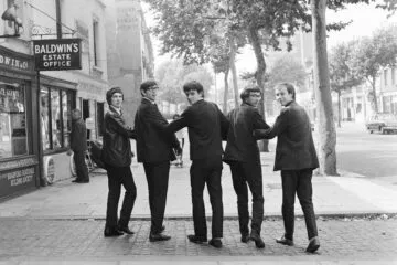Getty Images Embed: Group portrait of The Zombies walking down a street arm in arm in Chiswick, west London, 1965. L-R Rod Argent, Paul Atkinson, Colin Blunstone, Chris White, Hugh Grundy. (Photo by Stanley Bielecki/ASP/Getty Images)
